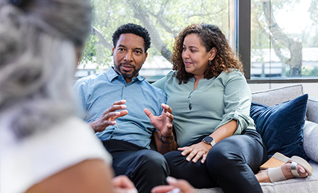 Couple chatting to lady on sofa