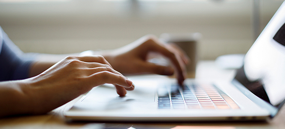  Image of someone typing on a laptop