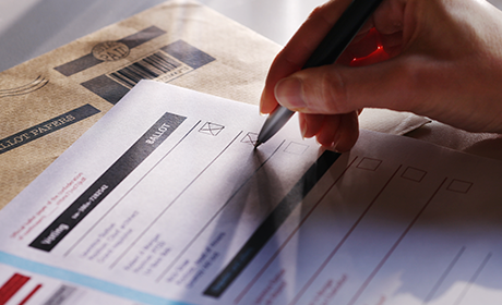Image of a hand signing a form