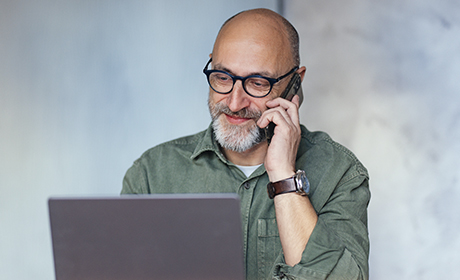 Man using his laptop and a phone