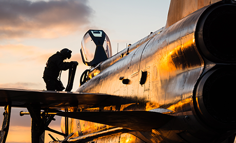 Image of a person on the wing of a fighter jet