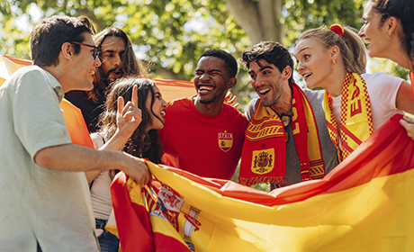Image of people smiling holding Spain's flag