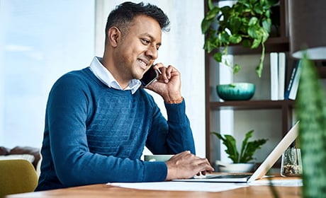 Man using a phone and a laptop