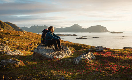 Lady sat on rock looking out at the water
